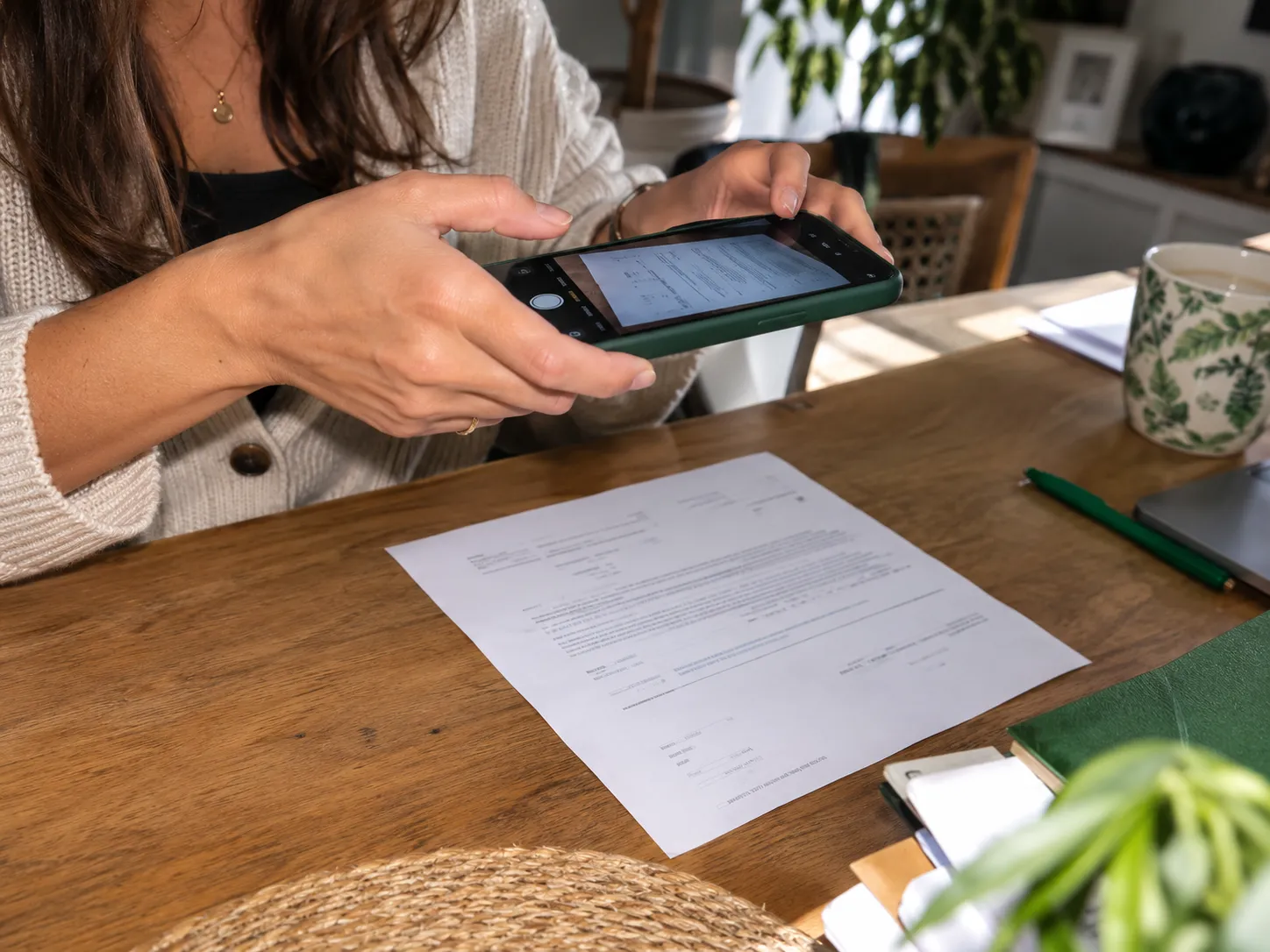Une cliente photographie un document posé sur sa table avec son smartphone.